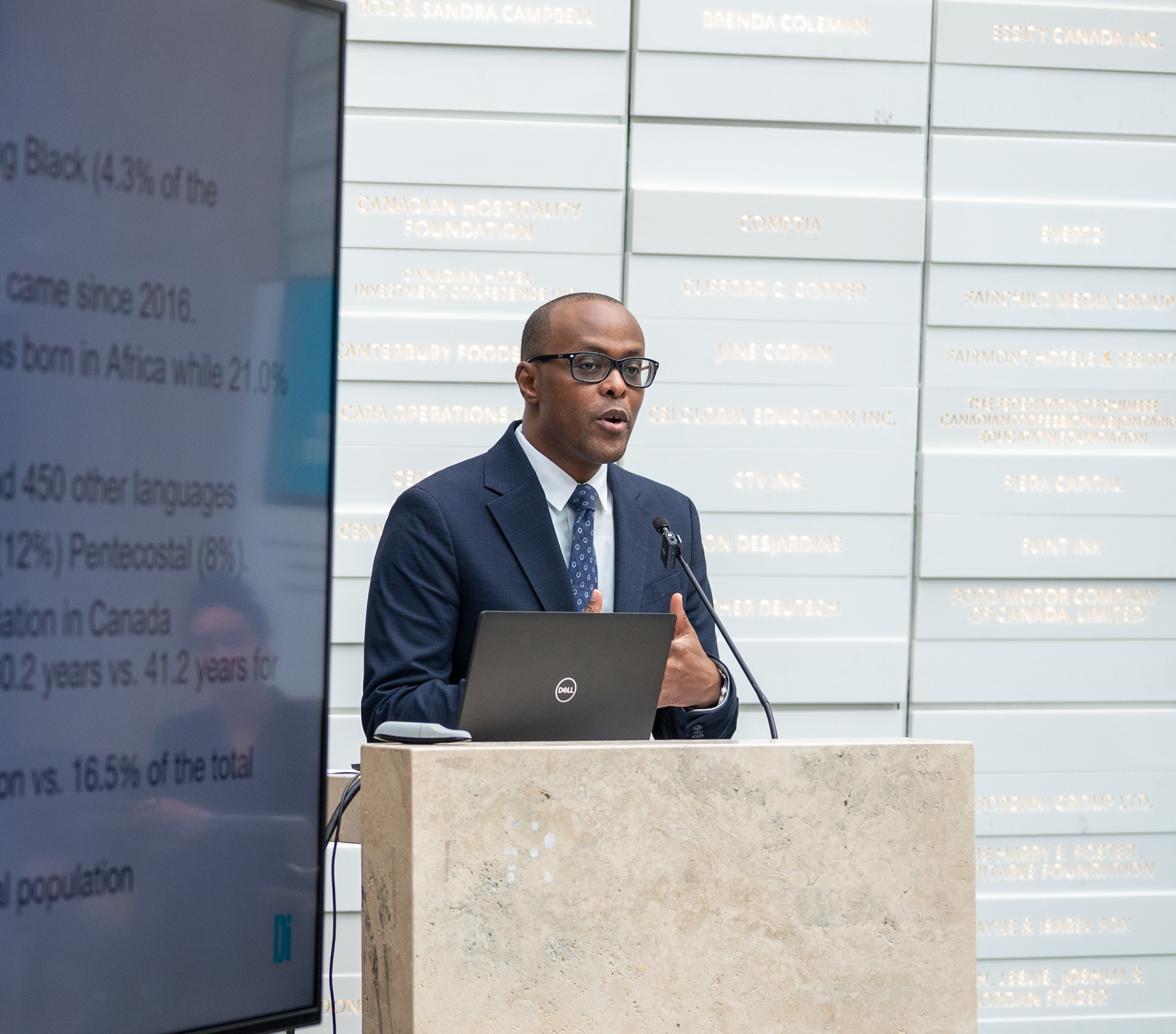 A Black man speaking at a podium.